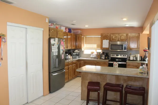 a kitchen with stainless steel appliances granite countertop a refrigerator and a stove top oven