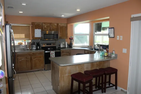 a kitchen with a stove a sink a microwave a dining table and chairs