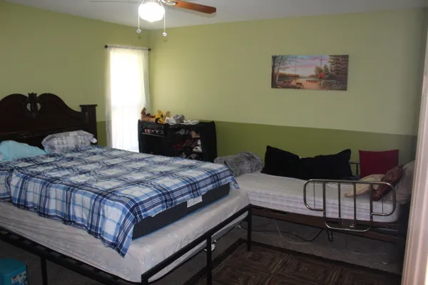 a bedroom with a bed and paintings on the wall