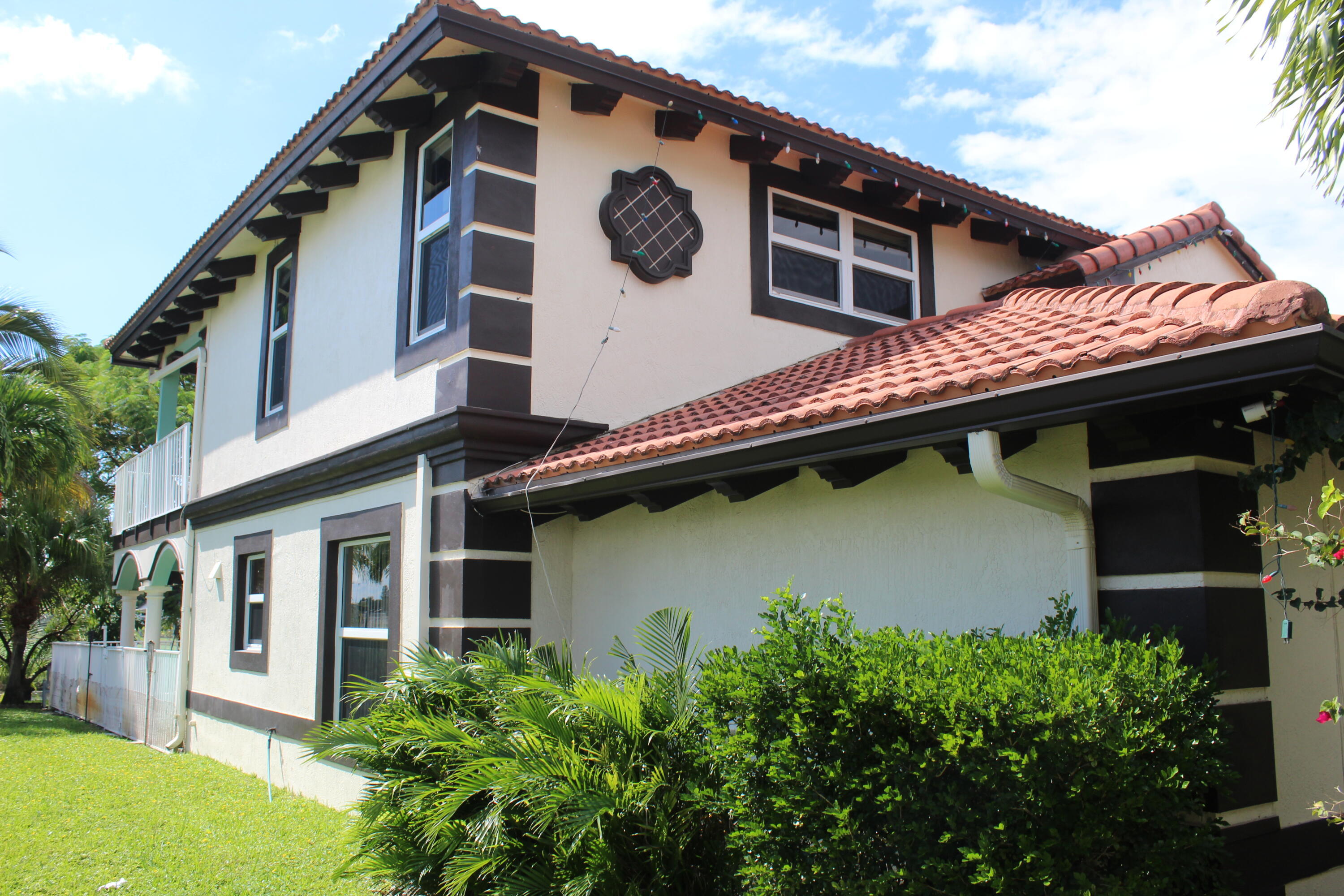 13847 Geranium Place Wellington, FL 33414 - Photo 2 of 50 a front view of a house with a garden