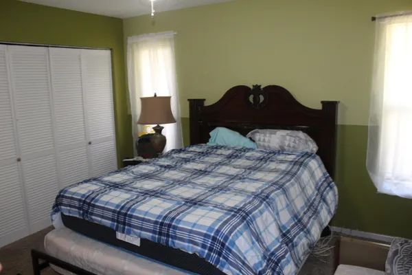 a bedroom with a bed lamp and a window