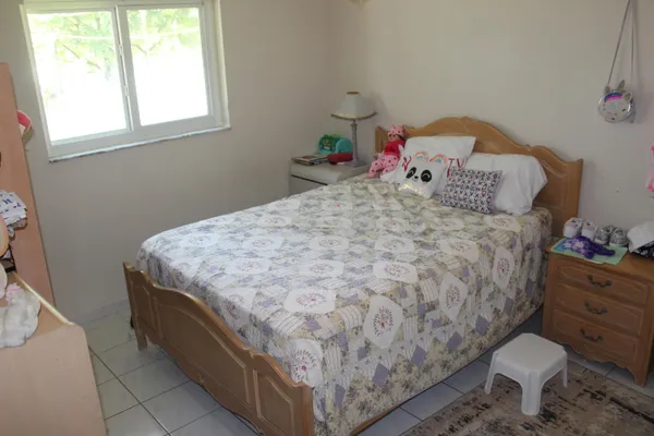 a bedroom with a bed and a dresser next to a window
