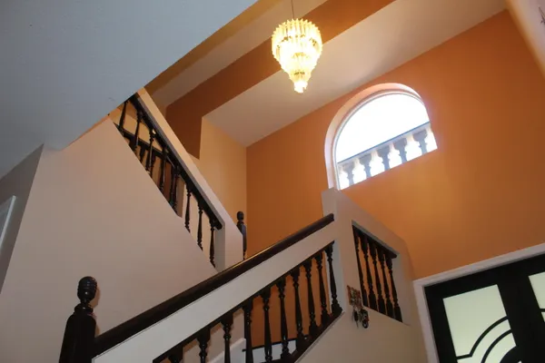 a view of staircase with railing and a chandelier