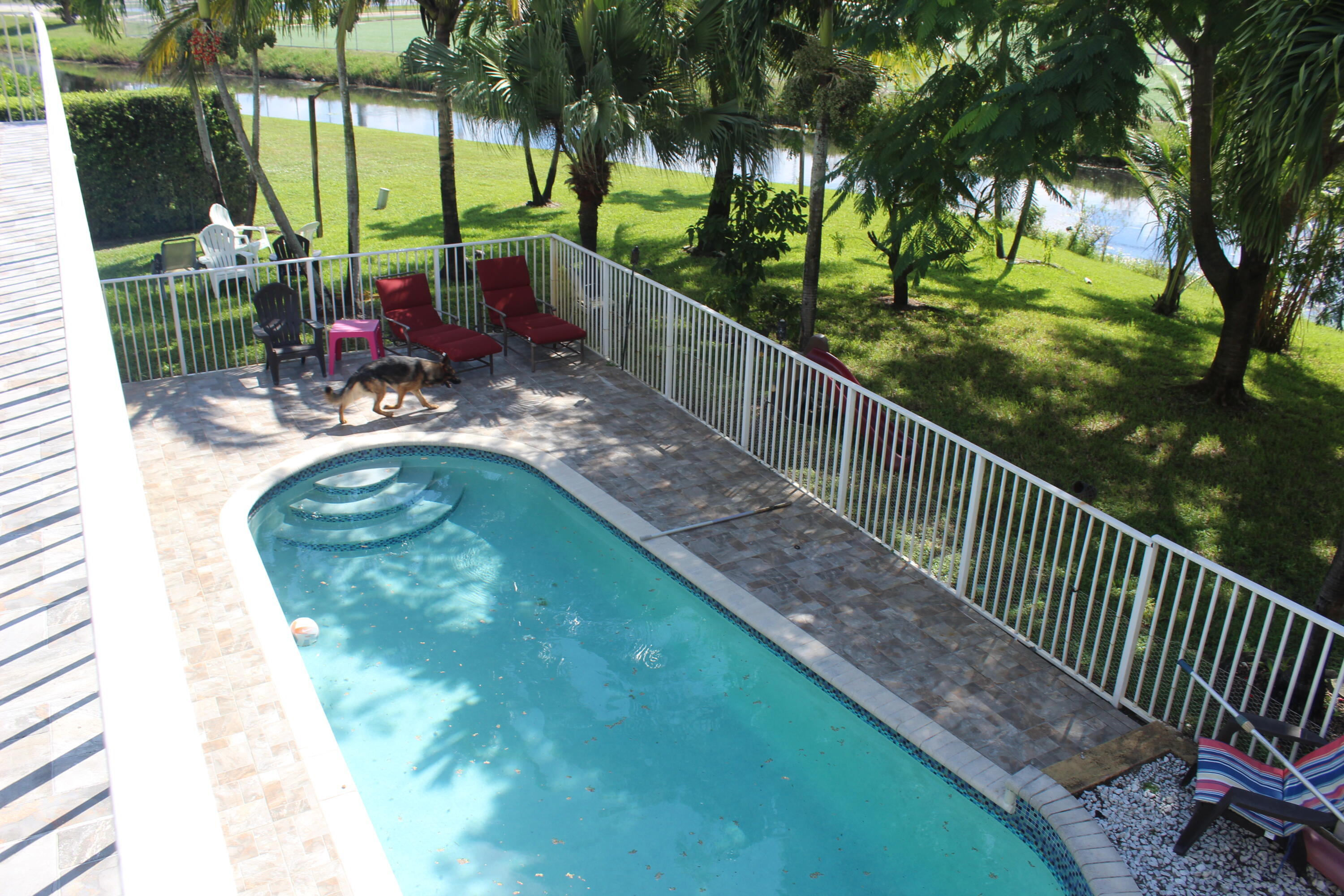 13847 Geranium Place Wellington, FL 33414 - Photo 46 of 50 a view of a swimming pool with a patio and a yard