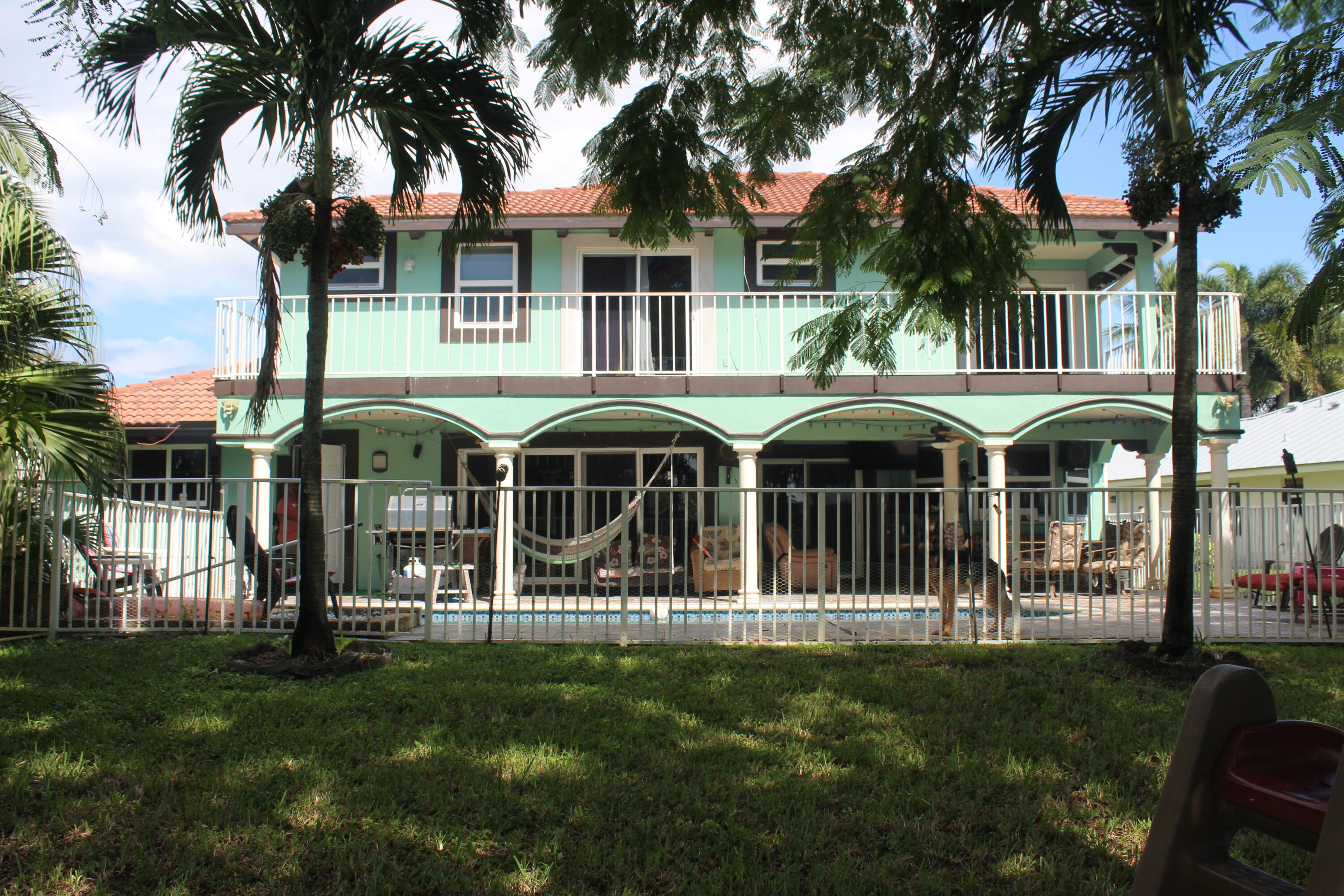 13847 Geranium Place Wellington, FL 33414 - Photo 6 of 50 a front view of a house with a garden