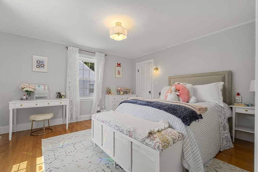 56 Allen Circle Milton, MA 02186 - Photo 22 of 34 a spacious bedroom with a bed and a table in it