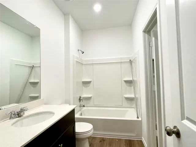 a bathroom with a granite countertop sink toilet a shower and a mirror