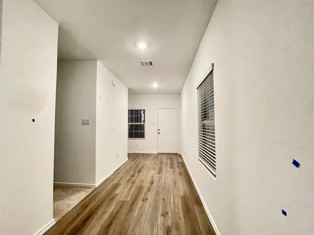 a view of a hallway with wooden floor