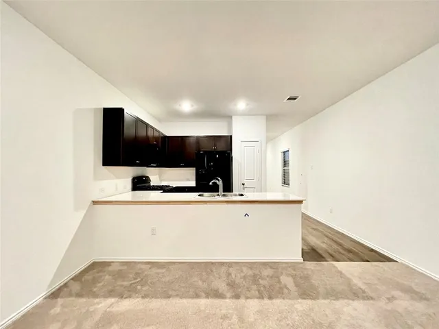 a view of kitchen with stainless steel appliances a sink and a refrigerator