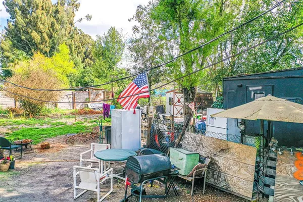 a front view of a house with a yard and a large tree