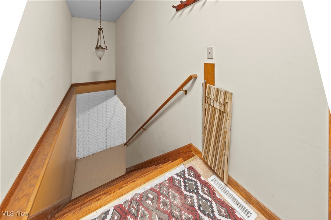 47147 Merriam Road Wellington, OH 44090 - Photo 39 of 49 Stairs leading to partially finished basement featuring wood finished floors