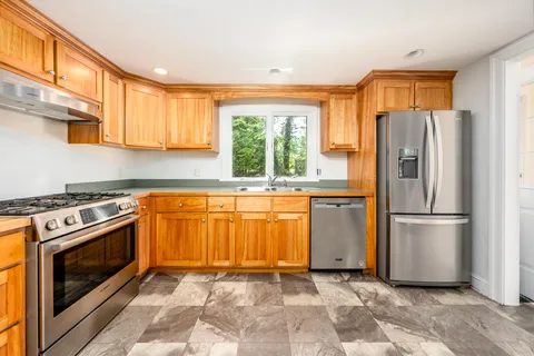 a kitchen with stainless steel appliances granite countertop a refrigerator and a stove
