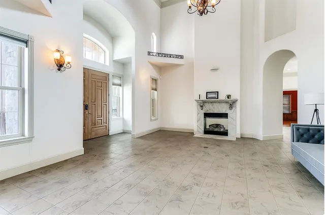 an empty room with windows and fireplace