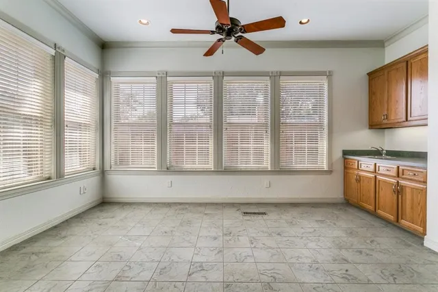 a view of an empty room with a kitchen and a window