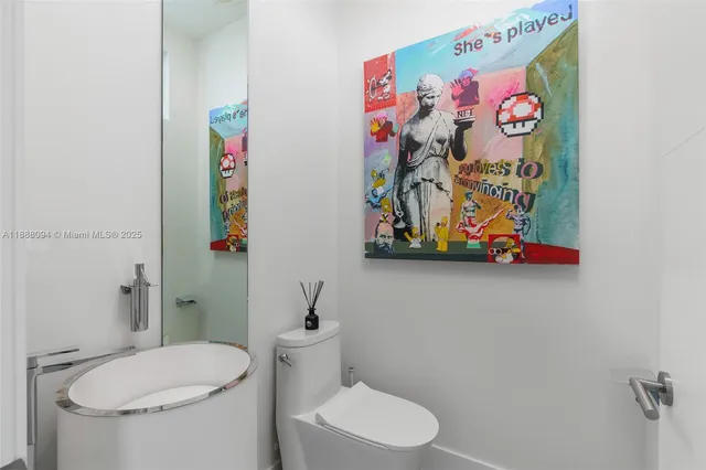 a white toilet sitting next to a bathroom sink