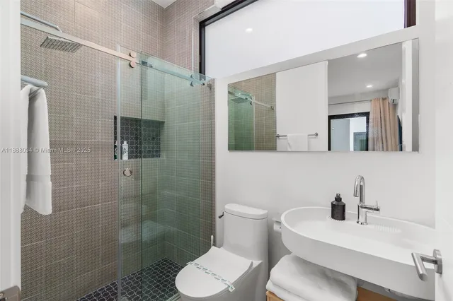 a bathroom with a sink toilet a mirror and shower