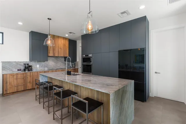 a kitchen with kitchen island a counter space a sink appliances and cabinets