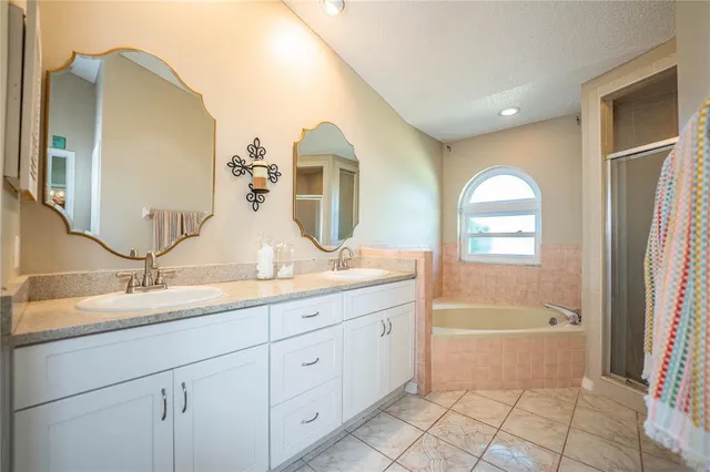 a spacious bathroom with a granite countertop sink a mirror and a bathtub