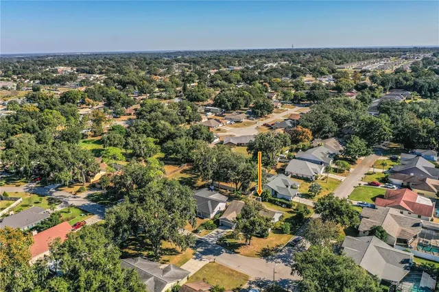 an aerial view of residential houses with outdoor space and trees