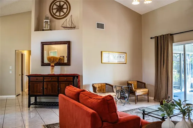 a living room with furniture a large window and a clock on the wall
