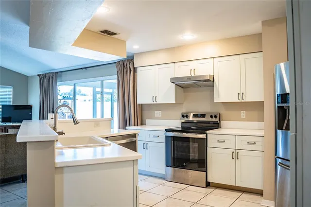 a kitchen with a stove cabinets and refrigerator