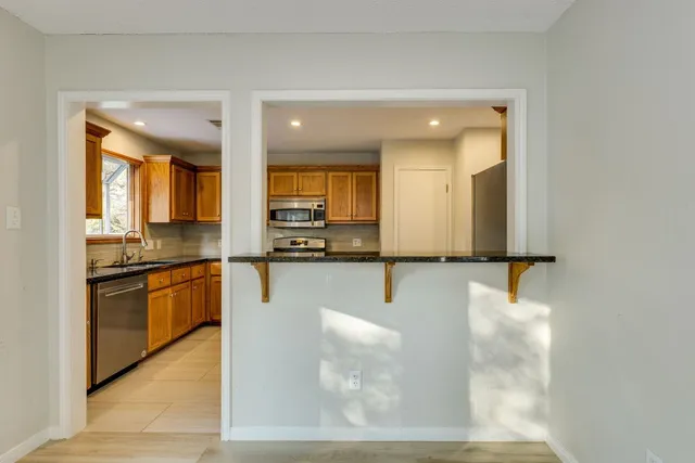 a kitchen with stainless steel appliances granite countertop a sink and a stove top oven