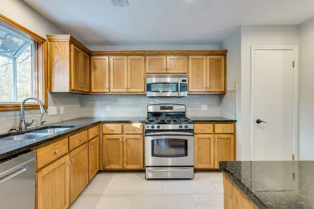 a kitchen with stainless steel appliances granite countertop a stove sink and cabinets