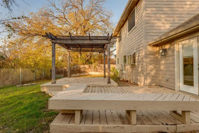 a view of a patio with table and chairs with wooden floor and fence
