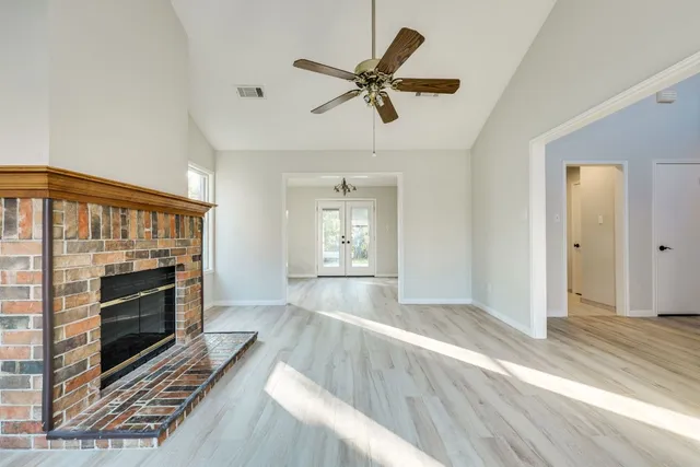a living room with wooden floor and a fireplace