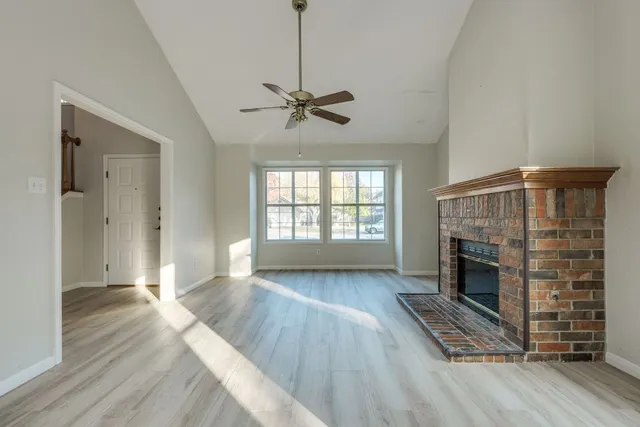 wooden floor fireplace and windows in an empty room