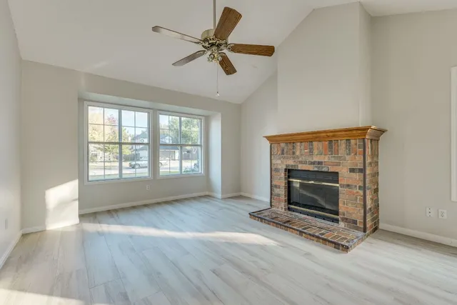 a living room with wooden floor and a fireplace