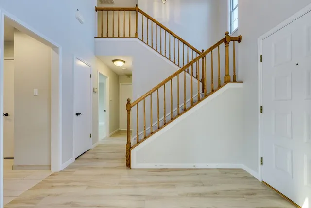 a view of staircase with wooden floor and white walls