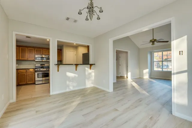 wooden floor in an empty room with a kitchen