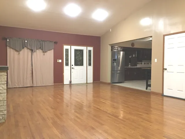 an empty room with wooden floor and door