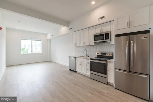 a kitchen with stainless steel appliances a refrigerator sink and microwave