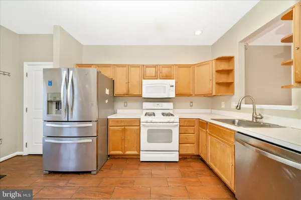 a kitchen with appliances a sink and a window