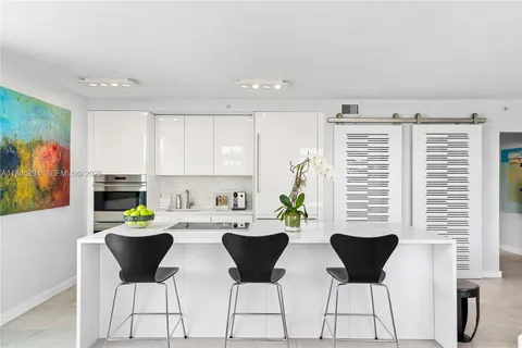 a kitchen with a dining table chairs and white appliances