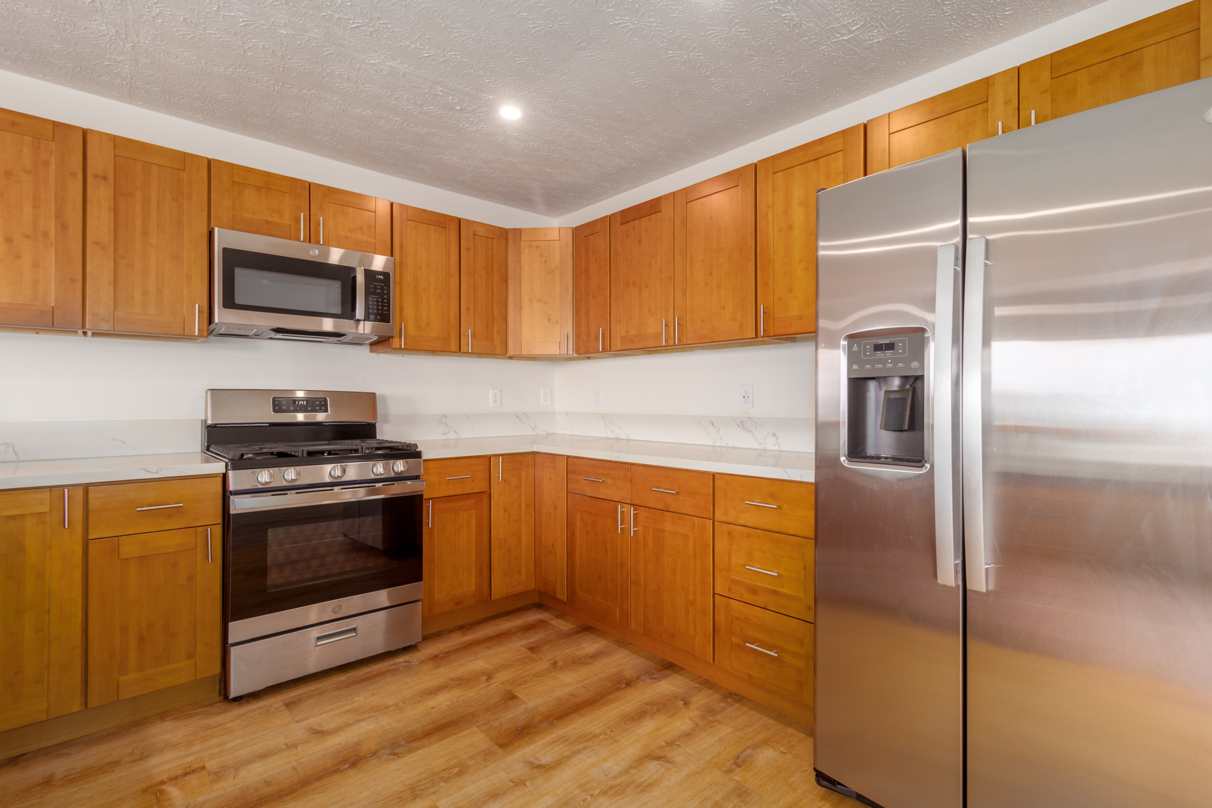 54-2378 Kynnersley Road Kapaau, HI 96755 - Photo 17 of 24 a kitchen with stainless steel appliances granite countertop a refrigerator microwave and sink