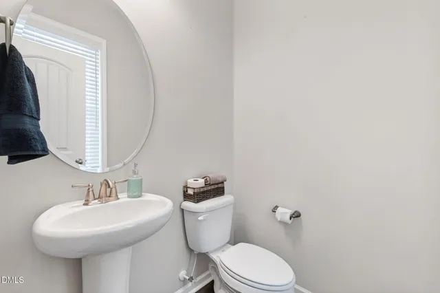 a bathroom with a sink mirror and toilet