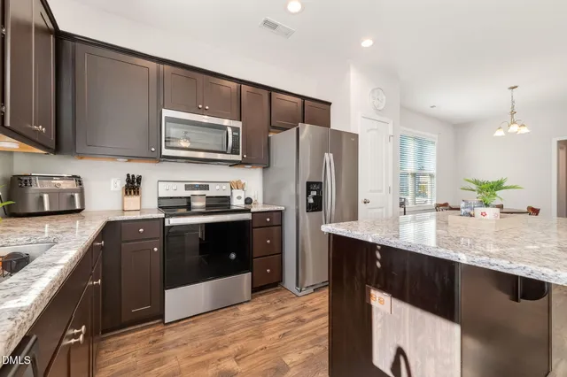 a kitchen with stainless steel appliances wooden cabinets a sink and a stove
