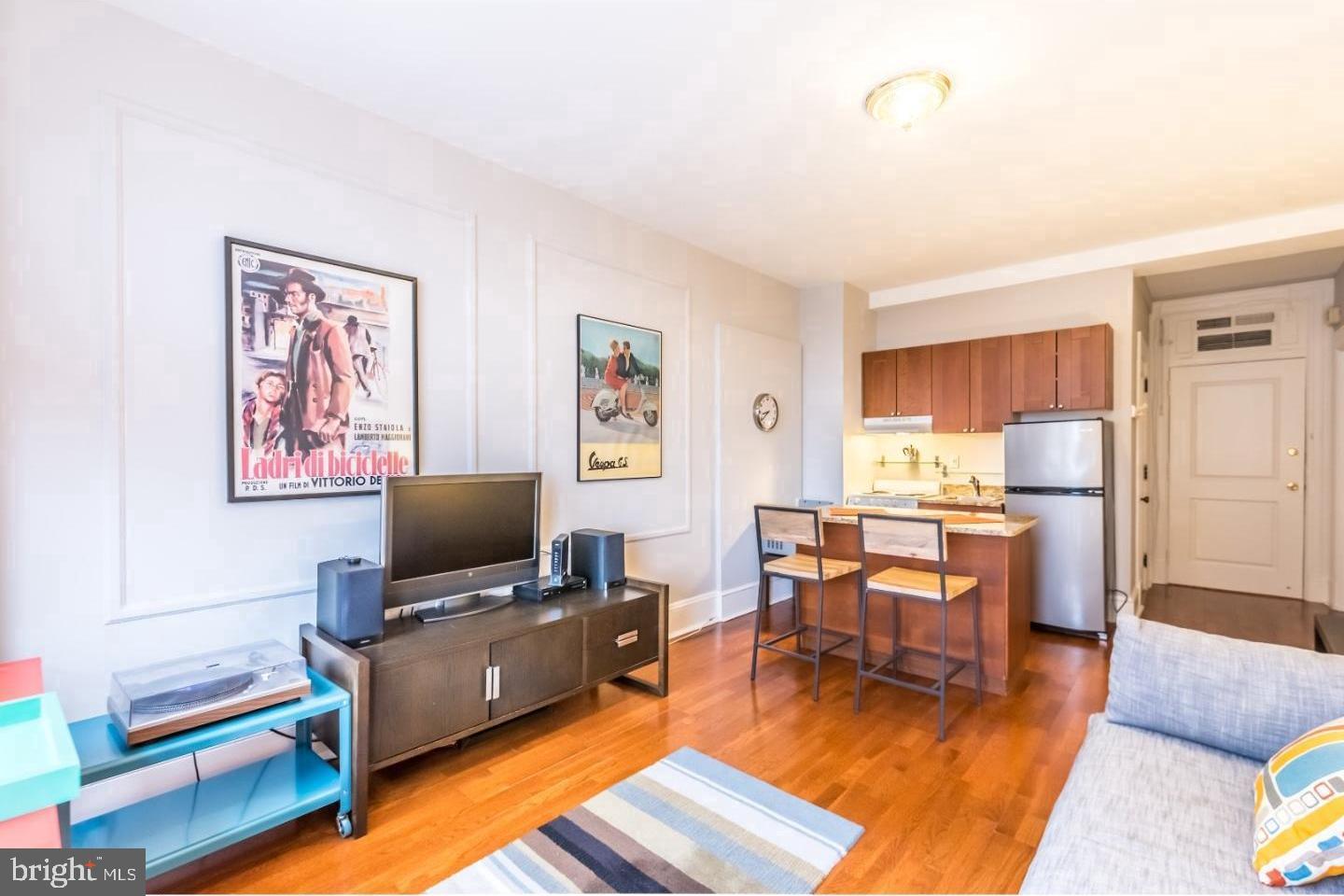 1324 Locust Street, Unit 1125 Philadelphia, PA 19107 - Photo 2 of 8 a living room with furniture and a flat screen tv