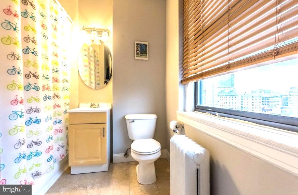 1324 Locust Street, Unit 1125 Philadelphia, PA 19107 - Photo 6 of 8 a bathroom with a toilet and a shower curtain