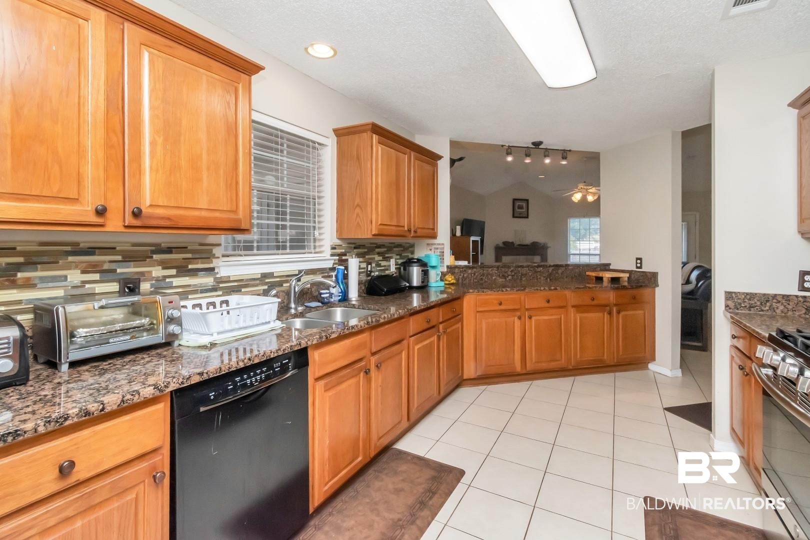 29221 Canterbury Road Daphne, AL 36526 - Photo 6 of 17 Kitchen featuring black dishwasher, a wealth of natural light, lofted ceiling, and sink