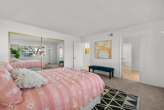 a bedroom with a bed and painting on the wall