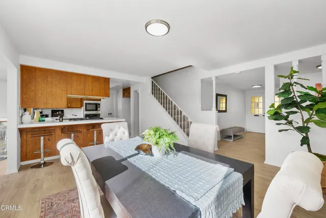 a living room with furniture a potted plant and a kitchen view
