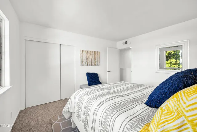 a bedroom with a bed and a painting on the wall