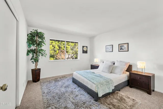 a bedroom with a bed and a potted plant
