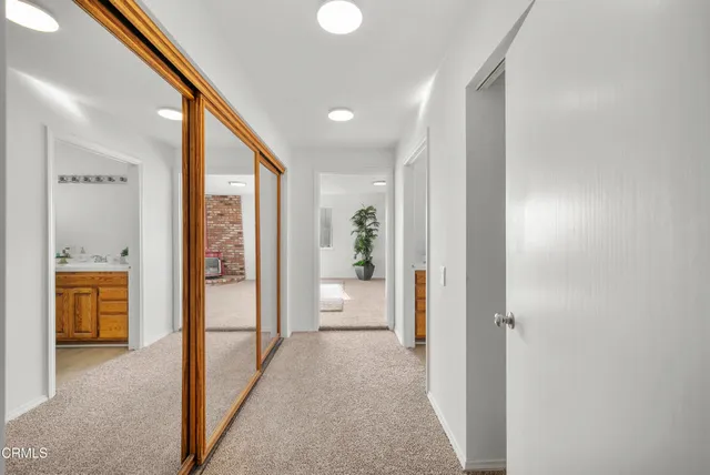 a view of hallway with livingroom and wooden floor