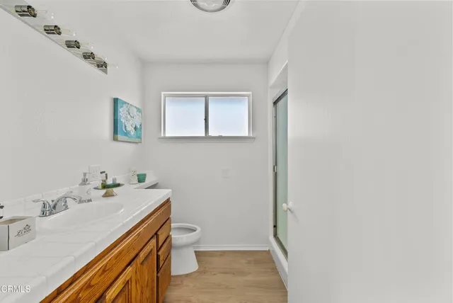 a bathroom with a sink mirror vanity and toilet