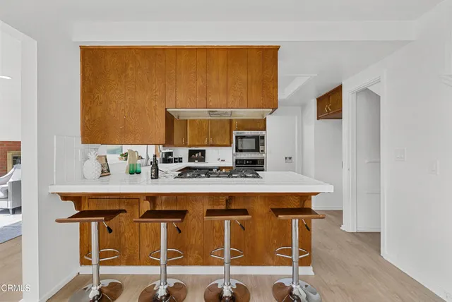 a view of a kitchen with stainless steel appliances granite countertop a sink and cabinets